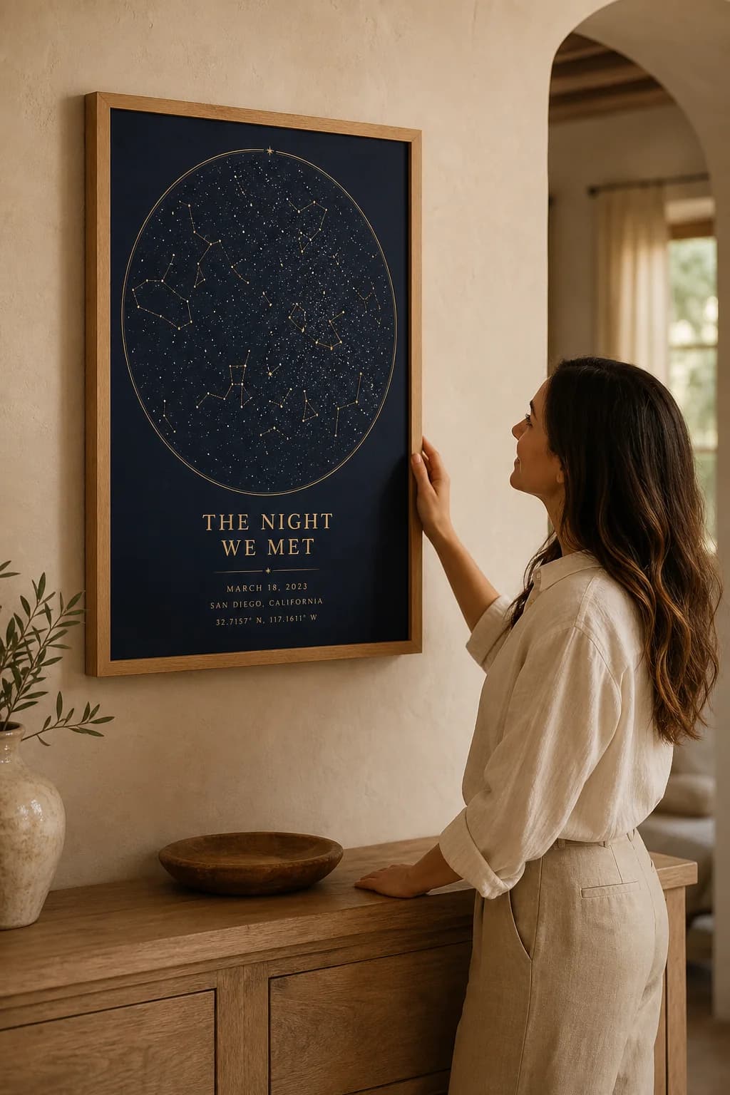 A woman admiring a framed custom starmap in a warm, modern home